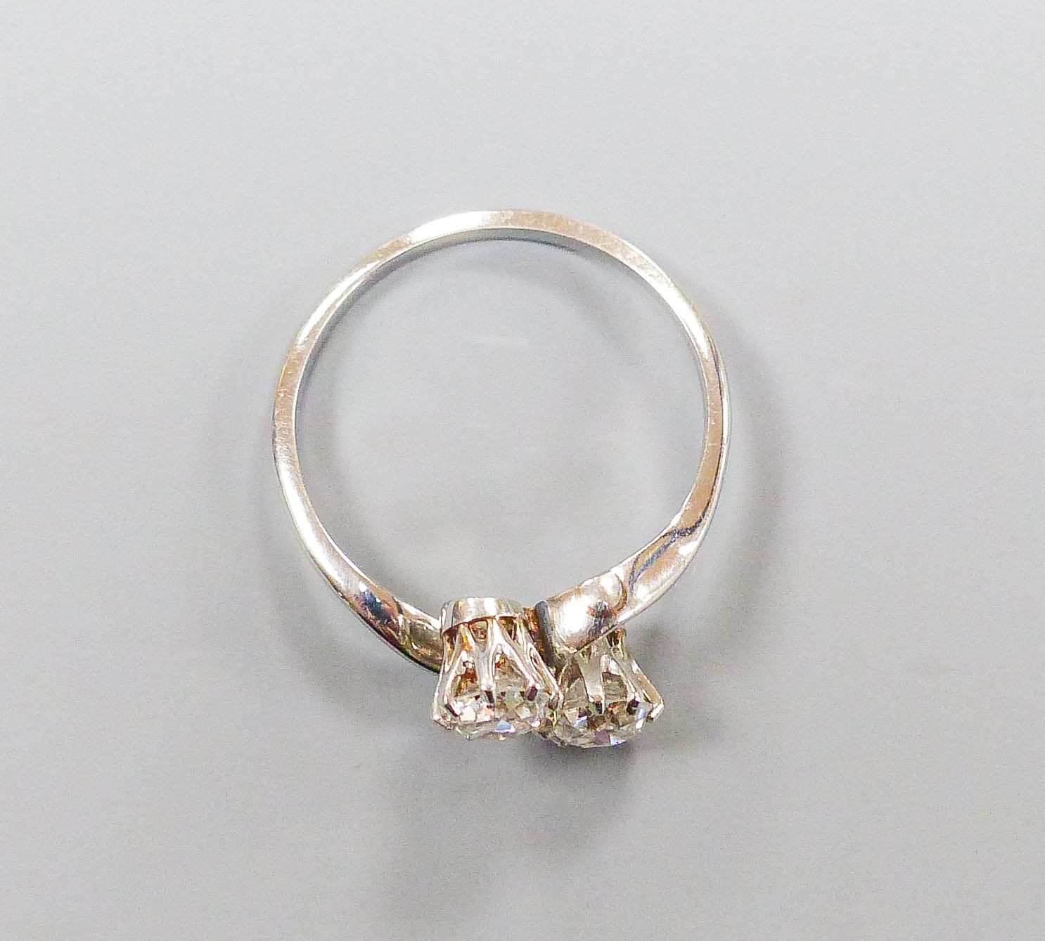A white metal and two stone diamond set crossover ring, size K, gross 2.4 grams